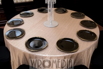 Nowoczesna dekoracja weselna ze złotym obrusem i czarnymi podtalerzami Nowoczesna dekoracja weselna ze złotym obrusem i czarnymi podtalerzami