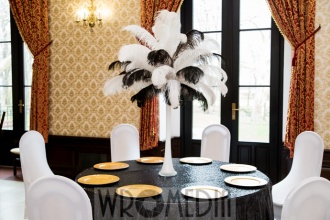 Czarny obrus, złote podtalerza i pióra w dekoracji sali weselnej Czarny obrus, złote podtalerza i pióra w dekoracji sali weselnej