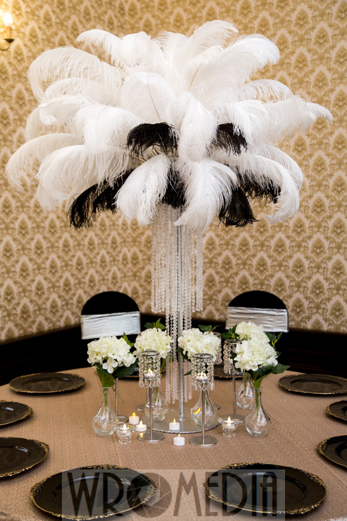 Czrno-biała dekoracja ślubna z metalicznym obrusem, piórami i kwiatami