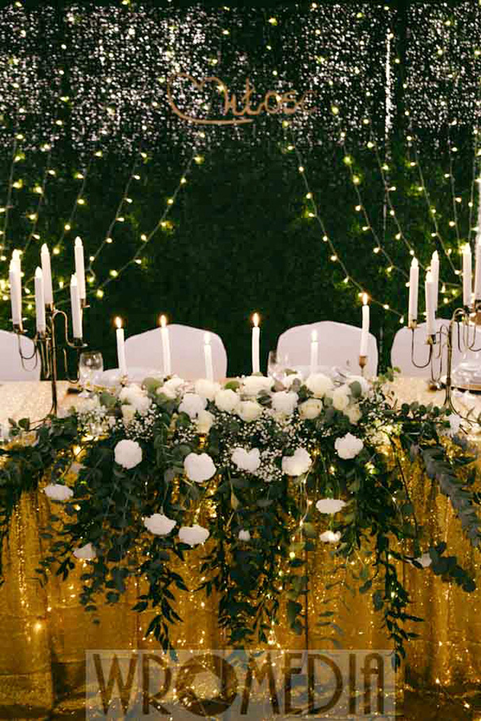 Stół młodej pary z zieloną ścianką i biało-zielonymi kwiatami