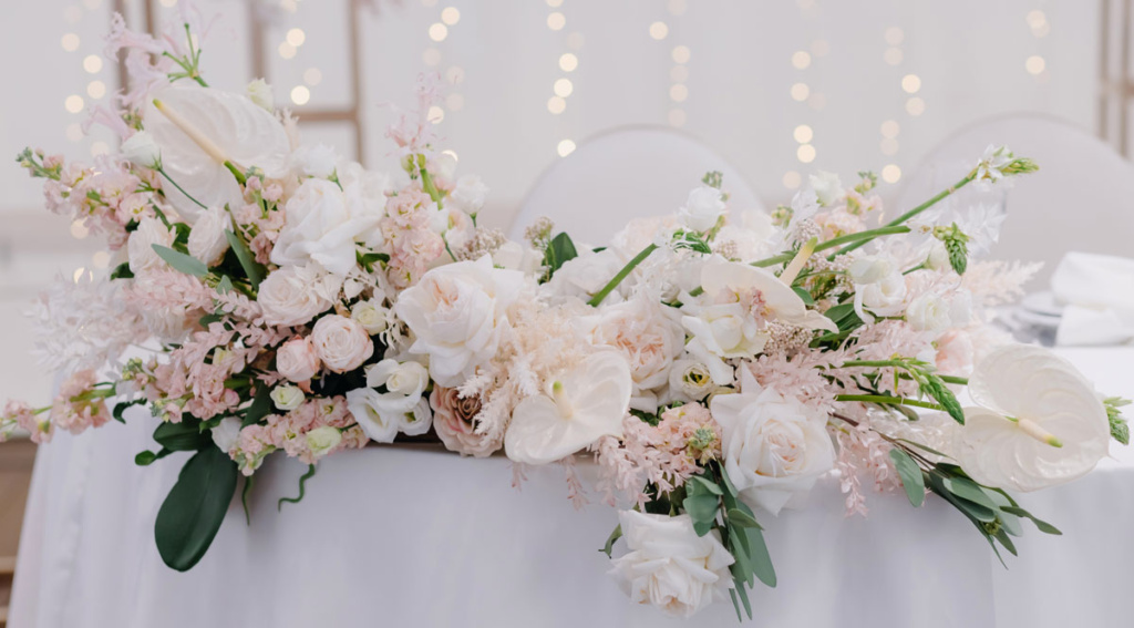 Pastelowa dekoracja stołu ślubnego z róż i eustomy